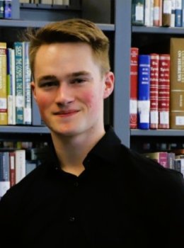 Student in front of library shelves